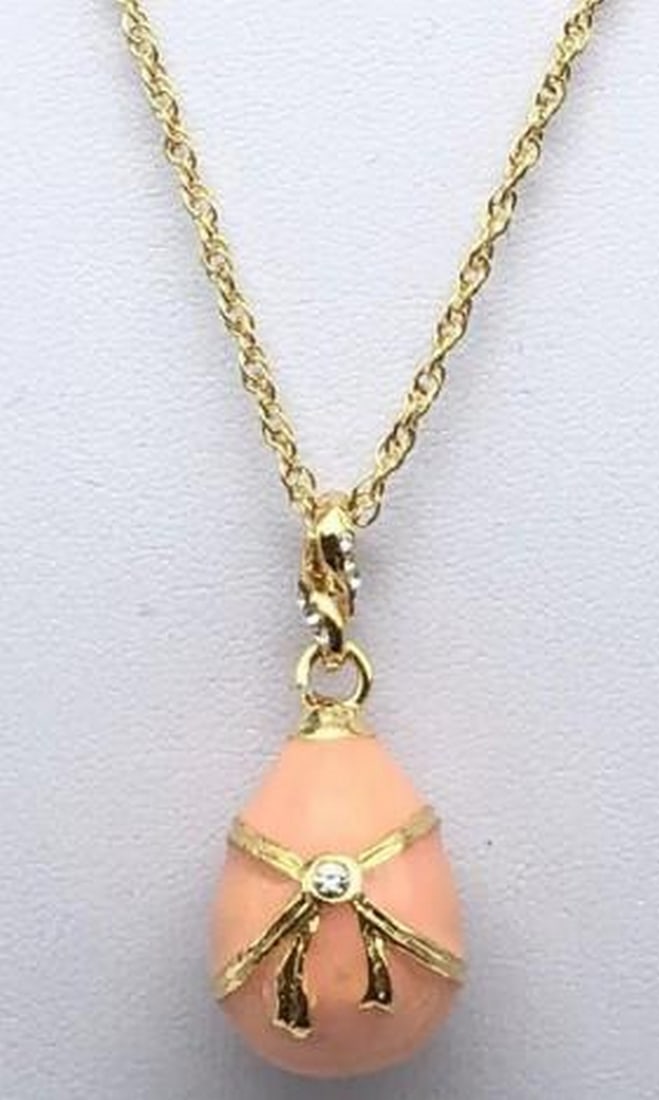 Rose Enamel Egg Pendant Necklace: Rose Enamel Egg Pendant Necklace Delicate and refined, this pink egg pendant necklace exudes timeless elegance. The soft rose enamel finish is accented with intricate detailing and a lustrous