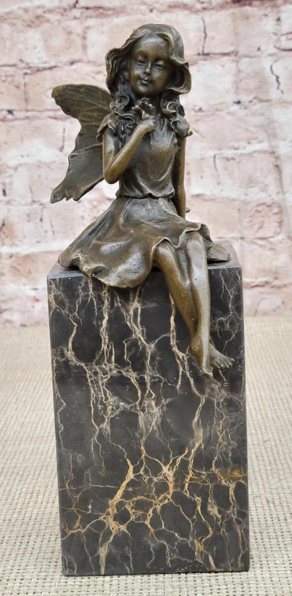 Fairy Holding Rose Original Bronze Statue - 9" x 8": Fairy Holding Rose Original Bronze Statue - 9" x 8" This enchanting bronze sculpture captures the essence of daydreaming with a whimsical fairy seated gracefully on a rock, gazing wistfully i
