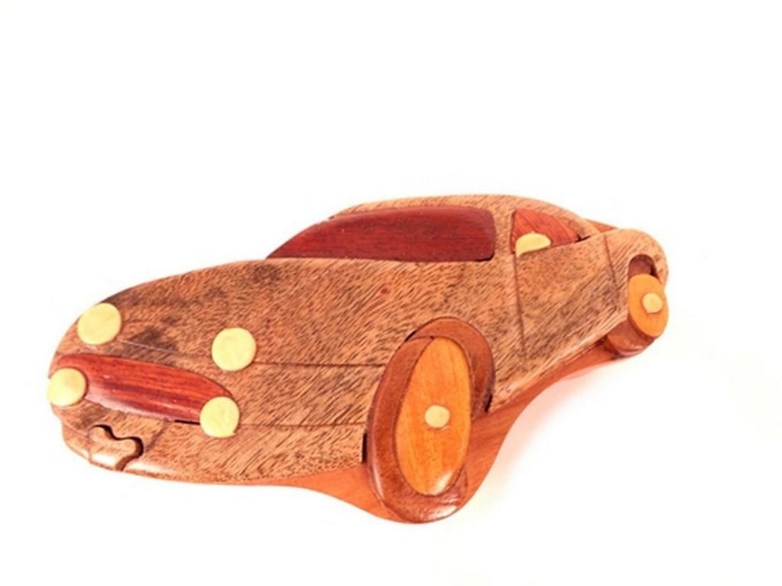 Car Puzzle Keepsake Box: Car Puzzle Keepsake Box This puzzle box is hand-carved and features a car design on the exterior, along with a red velvet-lined interior for storing small items. The box opens through a concealed