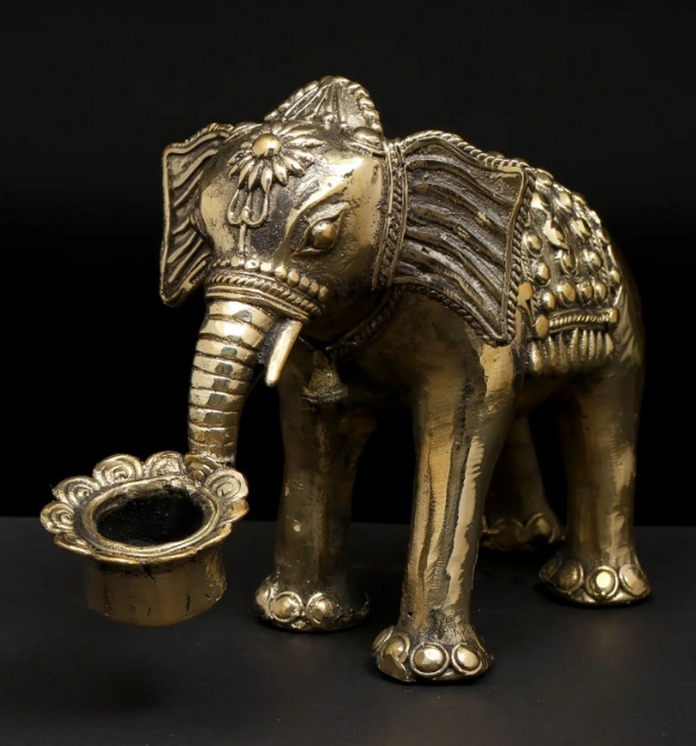 Brass Elephant Statue with Candle Holder – Dhokra Art: Brass Elephant Statue with Candle Holder – Dhokra Art An 8-inch brass elephant statue featuring an integrated candle holder, crafted in the traditional Dhokra art style. The piece emphasizes detail