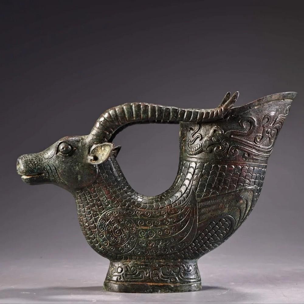Antique Bronze Sheep Wine Cup Statue: Antique Bronze Sheep Wine Cup Statue This exquisite Chinese antique features a hand-crafted bronze sheep holding a wine cup, showcasing delicate detailing and refined artistry. Symbolizing prosperity,