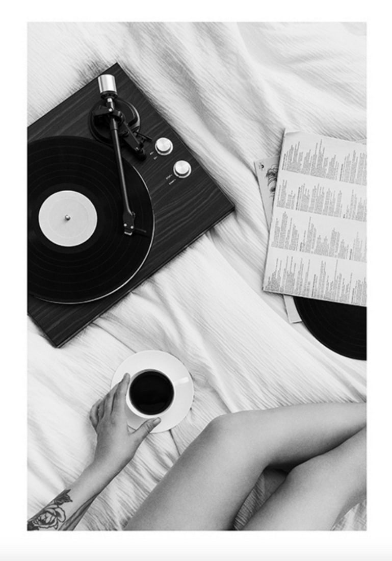 Black & White Vinyl Player Poster Paper: Black & White Vinyl Player Poster Paper Black and white poster of a woman in bed listening to music from a vinyl player and drinking coffee. Decorate your home with a cool and trendy poster. Perfe
