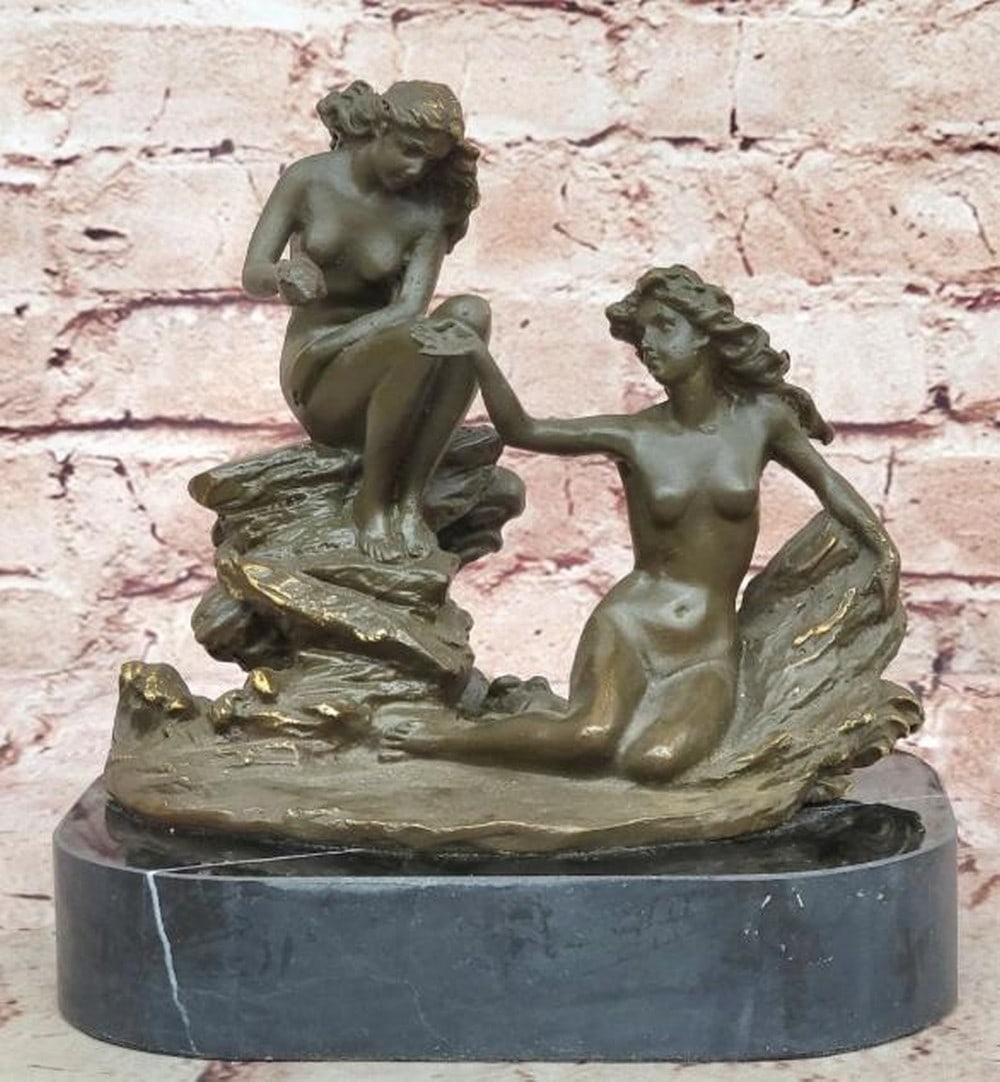 Gift of the Sea Bronze Sculpture: Gift of the Sea Bronze Sculpture A beautifully detailed bronze sculpture depicting two nude sea nymphs in a graceful and intimate moment by the shore. Seated on rocky outcrops, one nymph extends her
