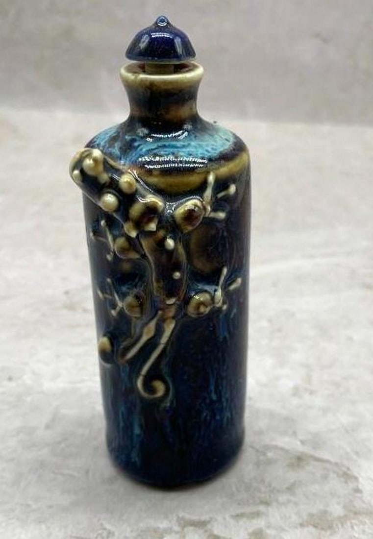 Blue Porcelain Snuff Bottle with Climbing Dragon Relief: Blue Porcelain Snuff Bottle with Climbing Dragon Relief Crafted from fine blue porcelain, this striking snuff bottle features a beautifully sculpted dragon in high relief, appearing to climb up the f