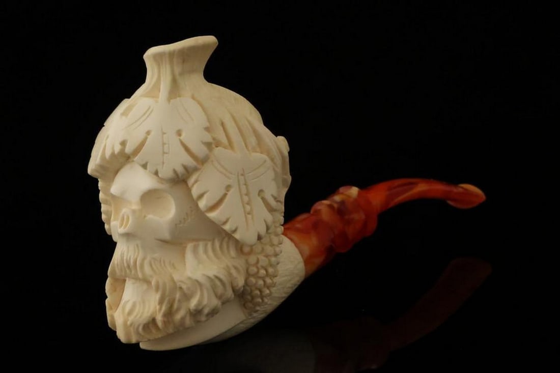Bacchus Skull Figure Meerschaum Pipe with Fitted Case: Bacchus Skull Figure Meerschaum Pipe with Fitted Case This finely hand-carved meerschaum pipe features a dramatic Bacchus skull motif, combining classical mythology with bold, intricate detailing. Th