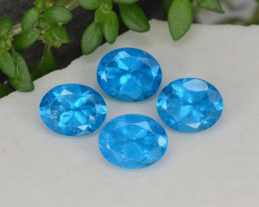 1.64 ct Oval Blue Apatite Gemstones: 1.64 ct Oval Blue Apatite Gemstones Introducing our set of four natural Blue Apatite gemstones, totaling 1.64 ct, each crafted in an oval facet with an average weight of 0.41 ct. Calibrated to 5 x 4