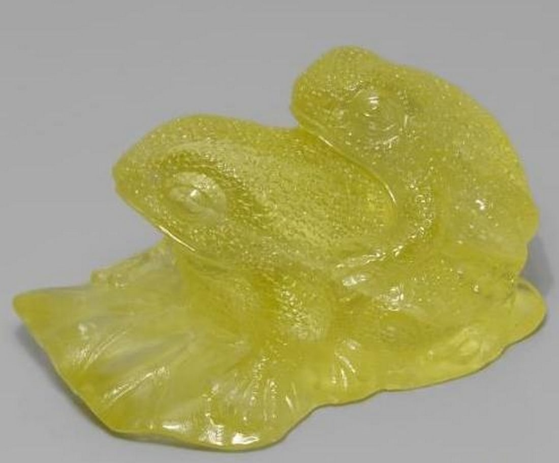 Medium Yellow Quartz Carved Frog Gemstone: Medium Yellow Quartz Carved Frog Gemstone This charming loose gemstone is carved from medium yellow quartz into the playful shape of two frogs stacked on top of one another. The soft, sunny yellow