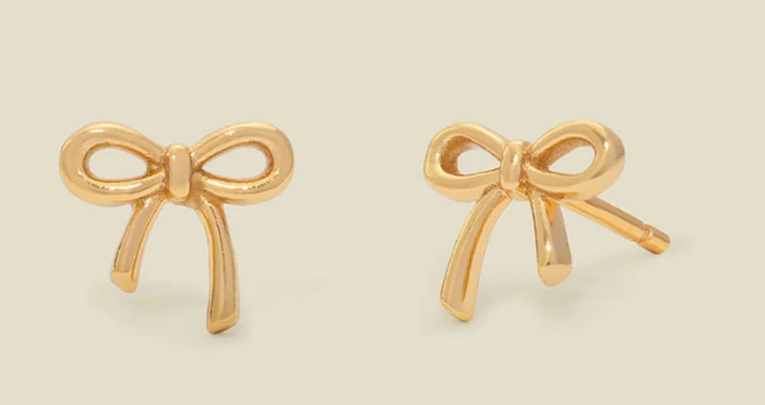 Vermeil Gold Bow Stud Earrings: Vermeil Gold Bow Stud Earrings Delicate and charming, these petite stud earrings bring a touch of coquette elegance to your collection. Featuring dainty bows with a polished finish, this timeless pa