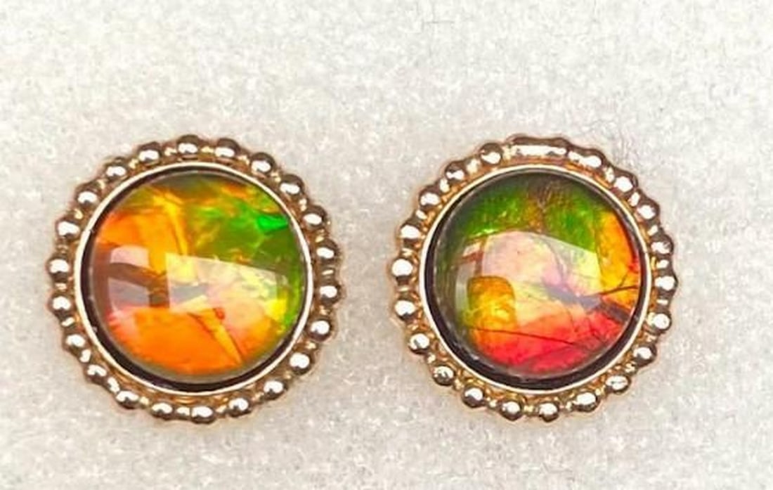 Primal Flame Ammolite Stud Earrings: Primal Flame Ammolite Stud Earrings These ammolite stud earrings capture the mesmerizing beauty of this rare gemstone, shimmering with dynamic hues that shift in the light. Each stone, formed from