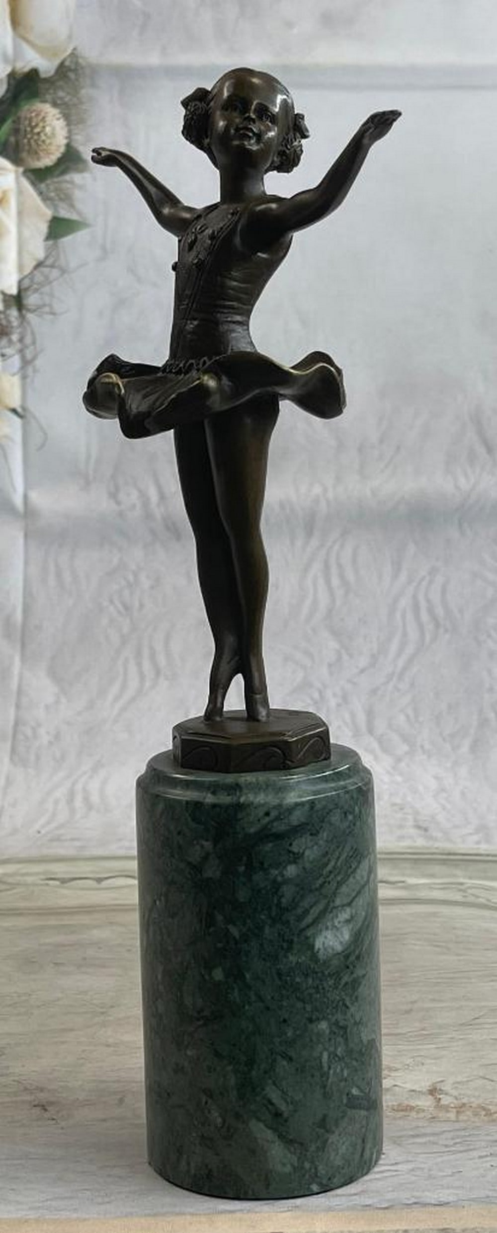 Vienna Ballerina Bronze Sculpture: Vienna Ballerina Bronze Sculpture A young girl dances for a loving crowd. She raises her ballerina arms out to her sides and twirls on the tips of her tiny toes. Her tutu frills billow around her. St