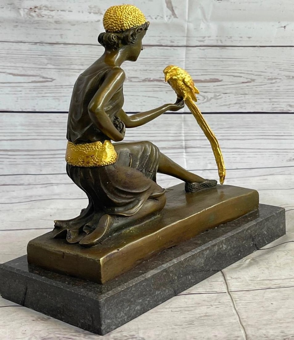 Girl With Gold Patina Parrot Bonze Sculpture: Girl With Gold Patina Parrot Bonze Sculpture She is a elegant bird whisperer. A well-dressed young woman on her way to a ritzy night out, steals a moment to play with a exotic parr