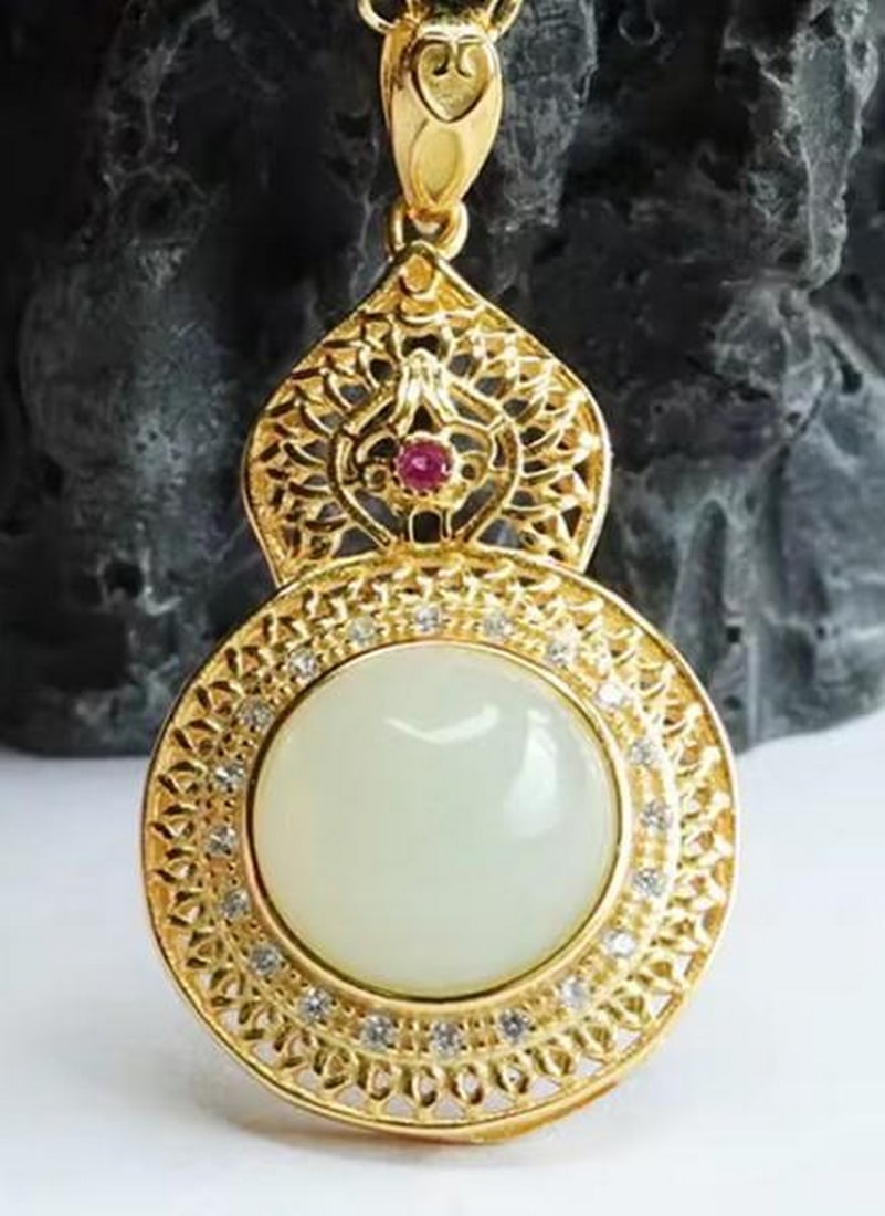 White Jade Pendant with Gold-Plated Sterling Silver: White Jade Pendant with Gold-Plated Sterling Silver A harmonious blend of elegance and artistry, this pendant features a smooth white jade stone framed in gold-plated sterling silver. Delicate white g