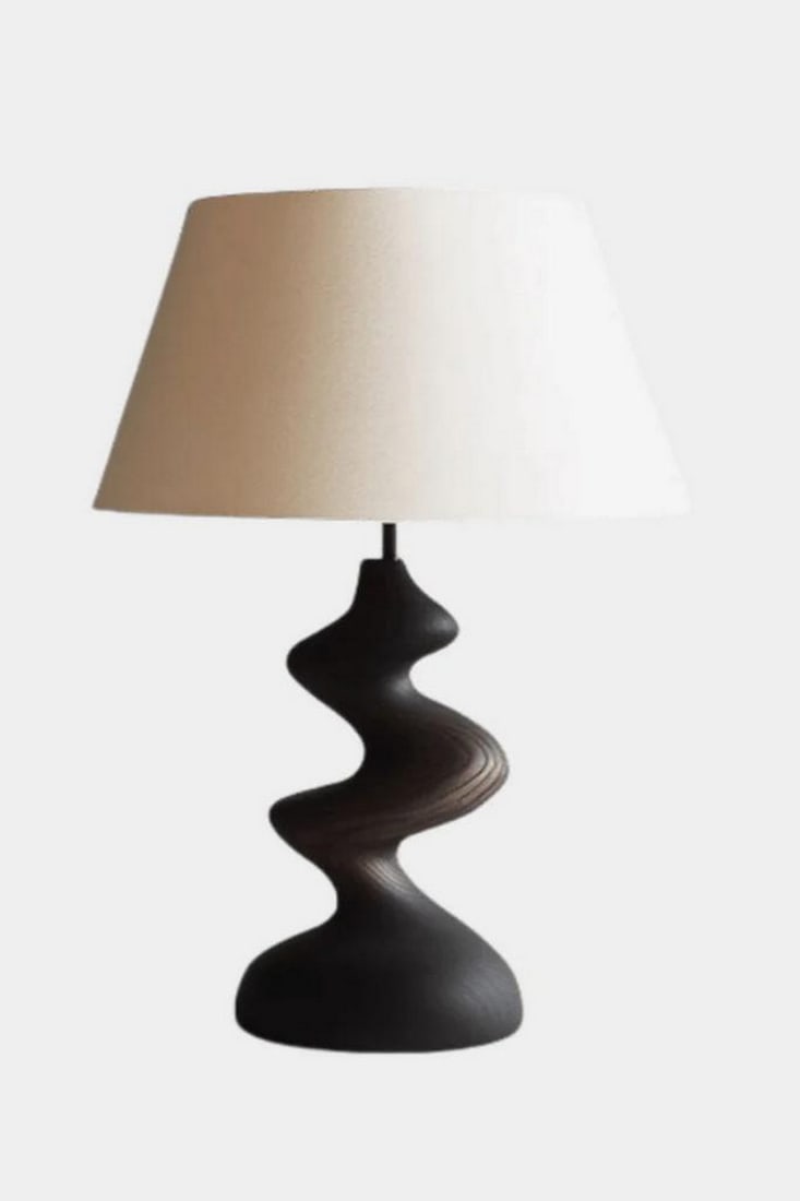 Wavy Contour Wooden Table Lamp: Wavy Contour Wooden Table Lamp Artistic and modern, this handcrafted table lamp features a sculptural base with a flowing, undulating form in a deep, smooth finish. The dynamic silhouette evokes