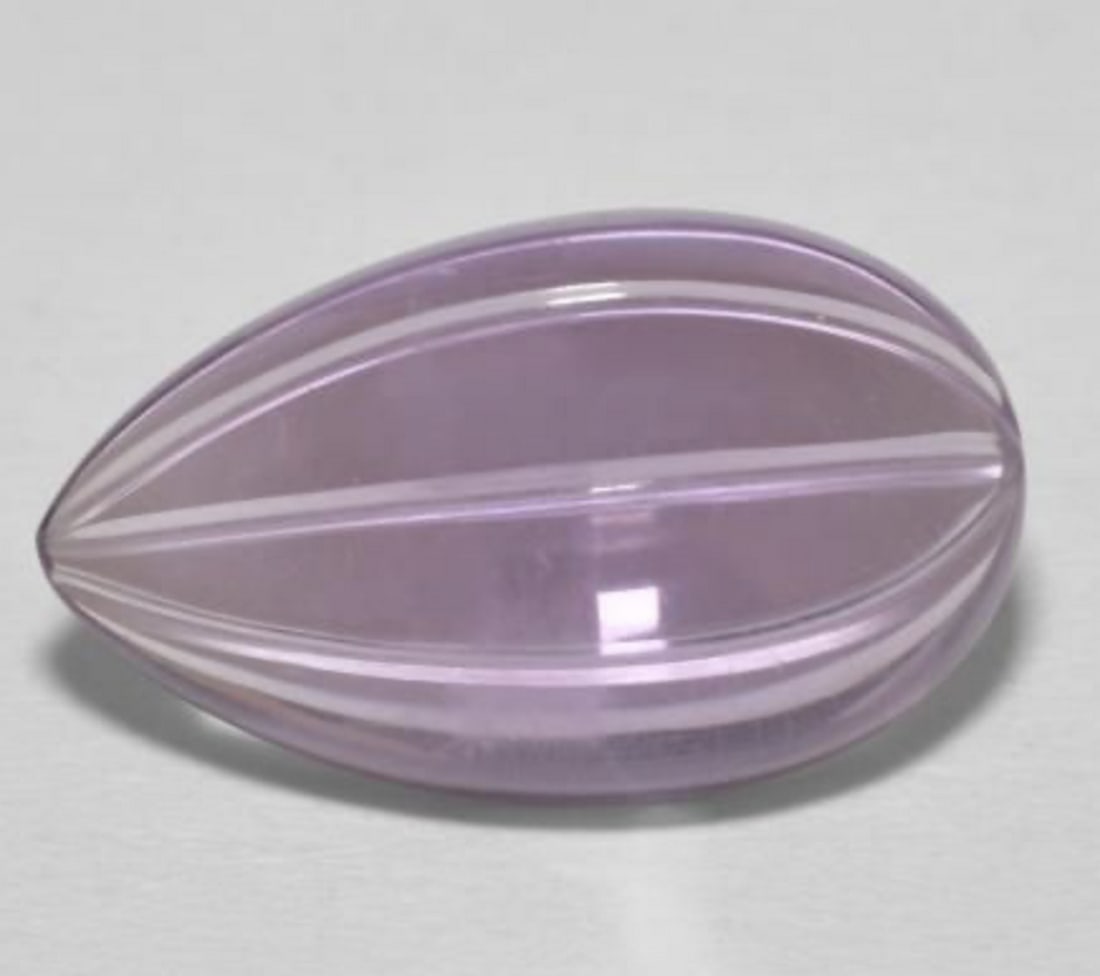 6.10ct Pear Shape Lilac Lust Amethyst: 6.10ct Pear Shape Amethyst Weight: 6.1ct Size: 16.35mm L x 9.8mm W x 5.9mm D Shape: Carved Pear Color: Lilac Clarity: transparent Treatment: Untreated Origin: Brazil View Photos For Furthe