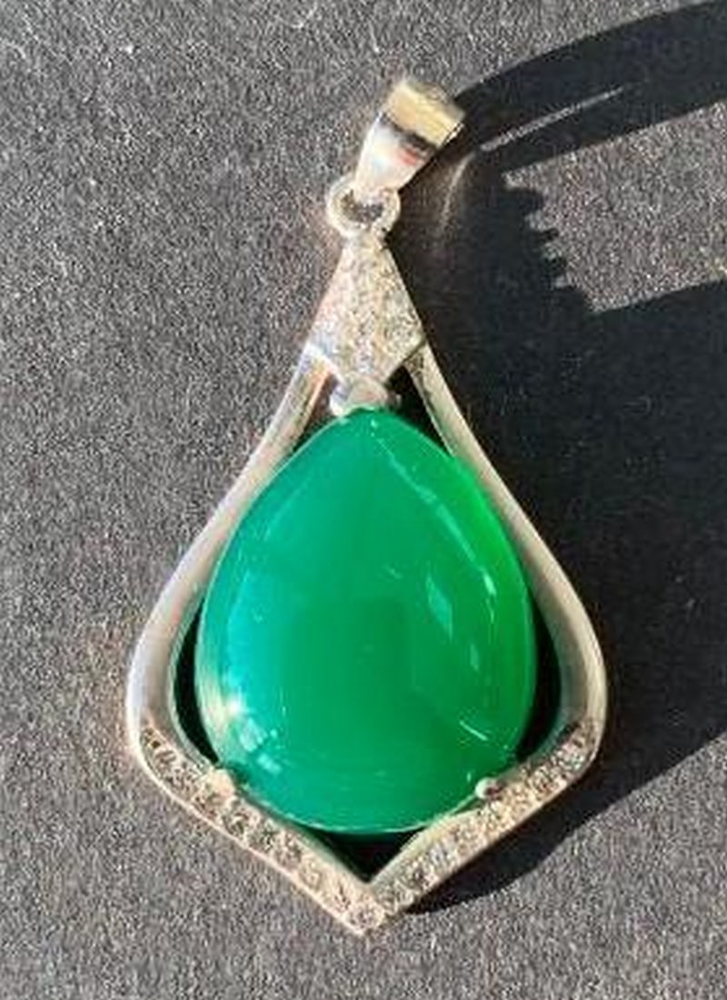Sterling Silver Pendant with Oval Green Stone: Sterling Silver Pendant with Oval Green Stone A striking blend of color and shine. This pendant features a large oval green stone set in sterling silver, enhanced with delicate white crystals embedded