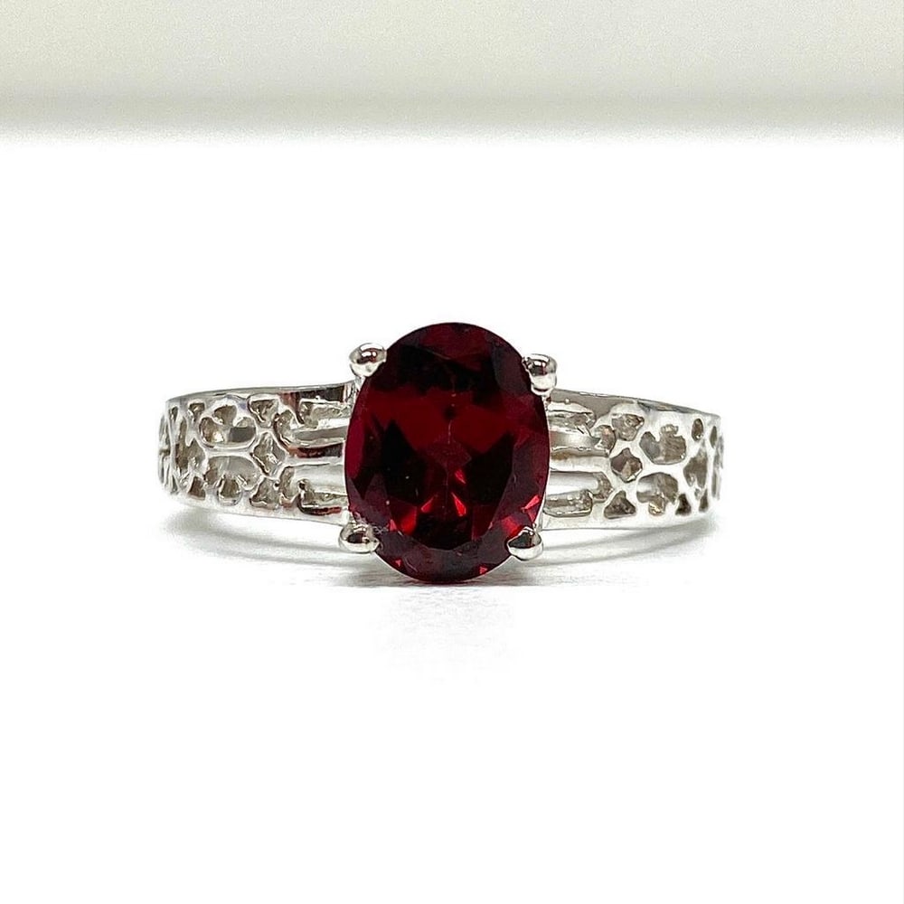 Large Garnet Gemstone on an Intricate 925 Sterling Silver Band: Large Garnet Gemstone on an Intricate 925 Sterling Silver Band. Garnets symbolize love and friendship. They represent the heart, inner fire, and are considered to be a life force. Garnets are also ass