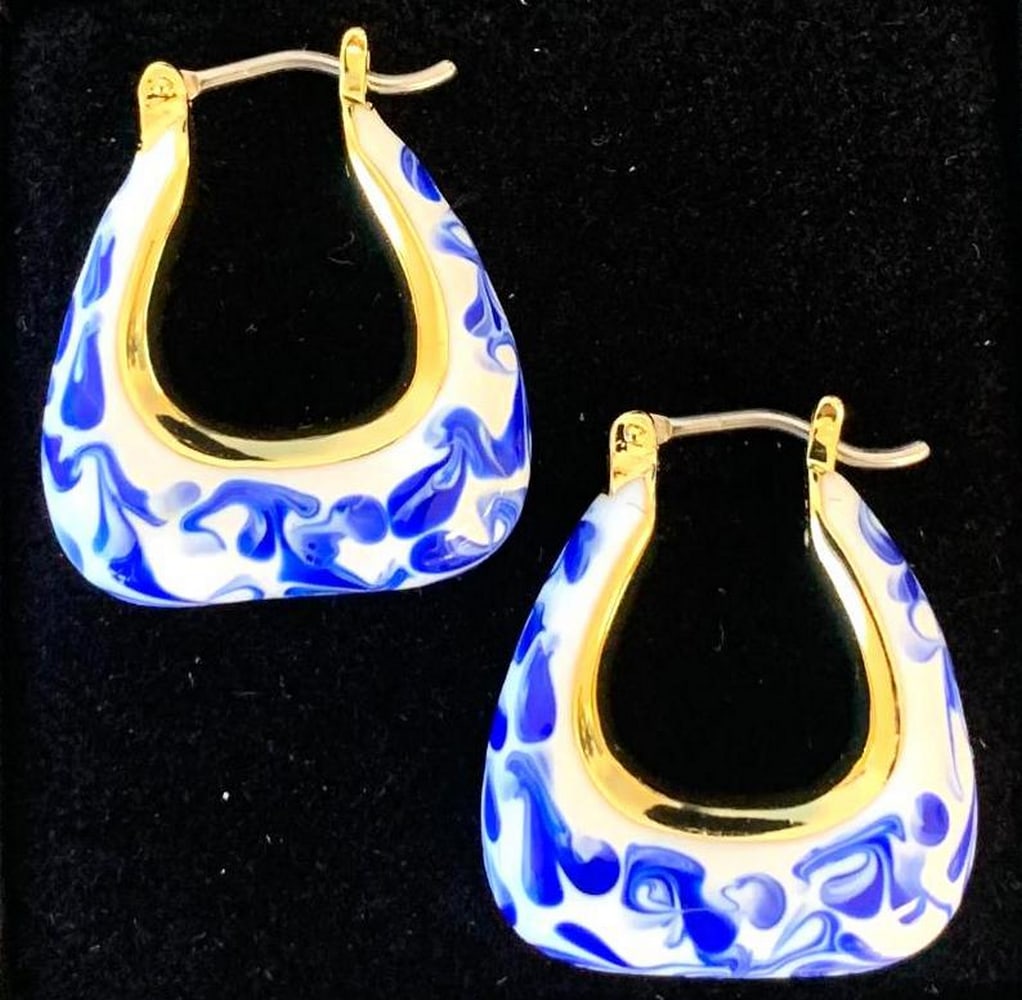 Santorini Blue Marble Hoops: Santorini Blue Marble Hoops Destined to stand out, these striking statement earrings bring effortless sophistication to any look. Plated in radiant 14k gold, their unique trapezoid-inspired silhouette