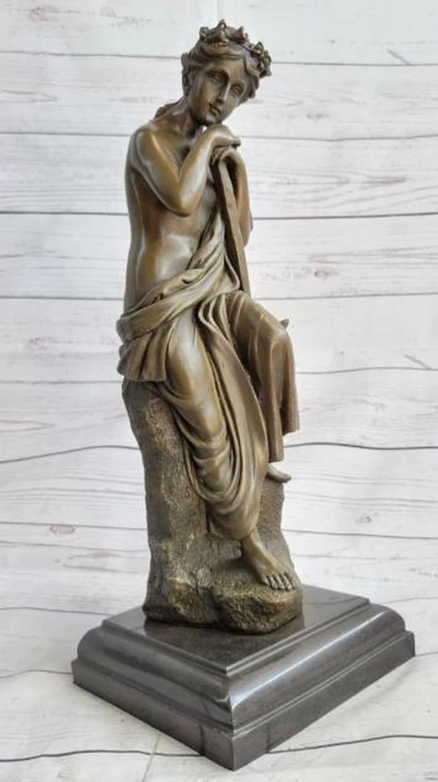 Semi-Nude Greek Goddess with Pickaxe Bronze Sculpture: Semi-Nude Greek Goddess with Pickaxe Bronze Sculpture A striking blend of classical beauty and symbolic power, this bronze sculpture depicts a semi-nude Greek goddess seated in quiet repose, her head 