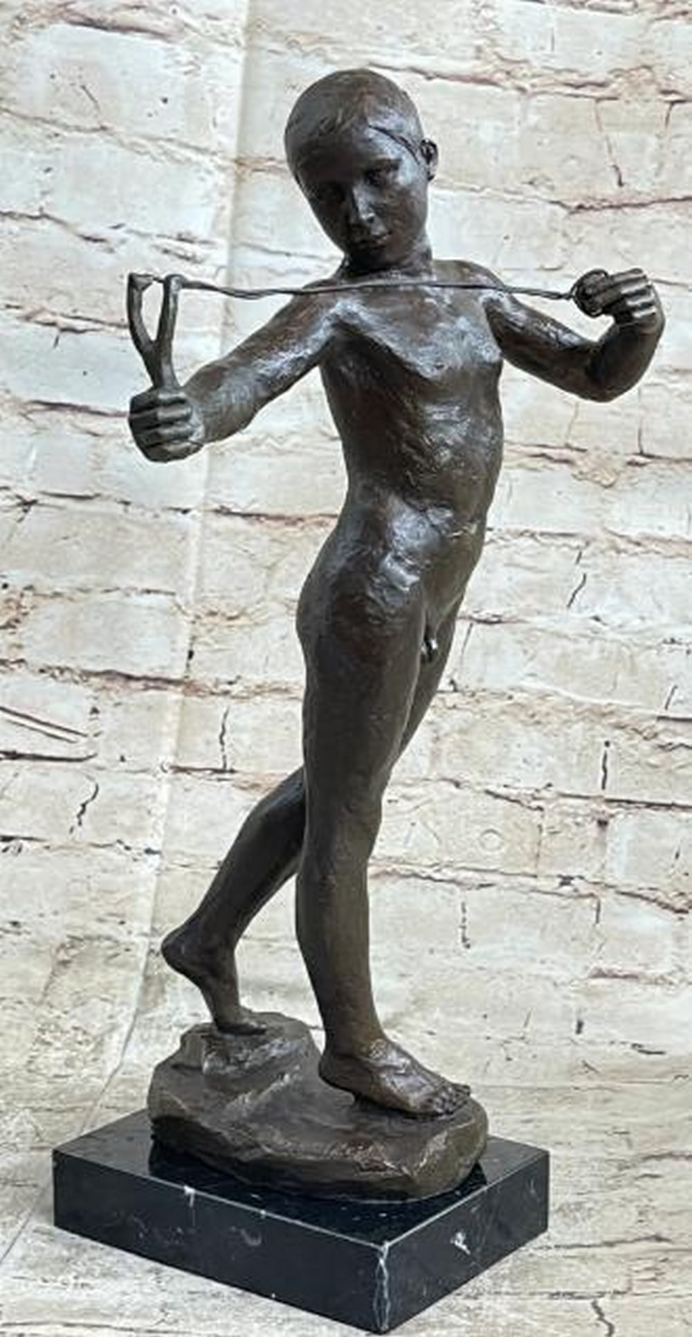 Young Rebel: Nude Boy with Slingshot Bronze Sculpture: Young Rebel: Nude Boy with Slingshot Bronze Sculpture Full of youthful defiance and classical charm, this hot cast bronze reproduction sculpture captures a nude boy holding a slingshot with quiet conf
