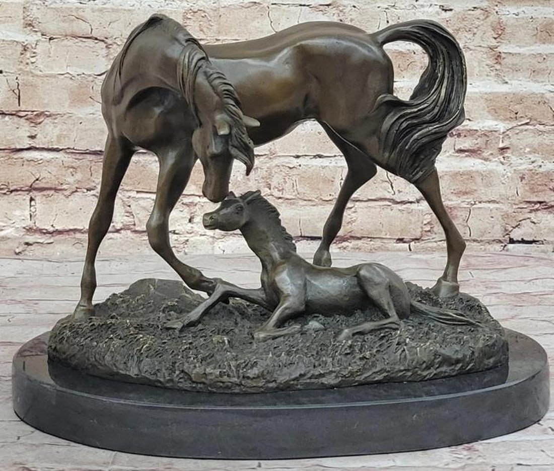 Mare and Foal Bronze Sculpture: Mare and Foal Bronze Sculpture This touching reproduction bronze sculpture captures the heartfelt connection between a mare and her foal. The foal rests gently on the ground, head lifted in quiet trus
