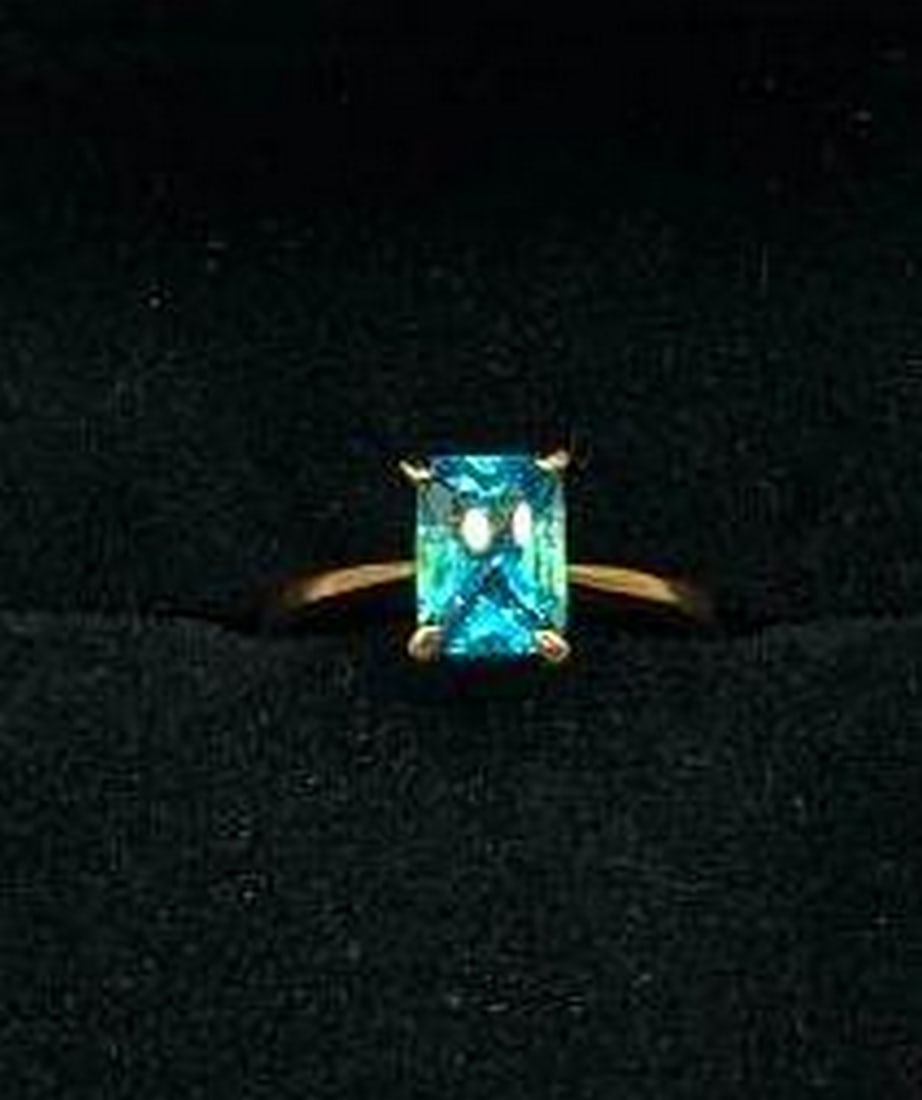 Cushion Cut Blue Stone Ring: Cushion Cut Blue Stone Ring Bold yet refined, this ring features a striking cushion cut blue stone that radiates depth and brilliance from every angle. The vibrant gemstone is set atop a gleaming 18KT