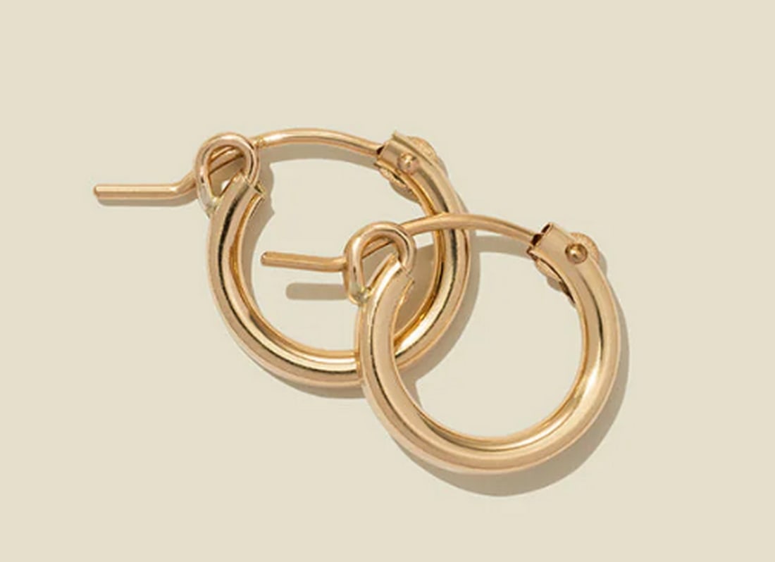 14K Gold Filled Maude Hoop Earrings: 14K Gold Filled Maude Hoop Earrings Your search for the perfect hoop ends here. These midi hoop earrings feature a hinge-style closure for effortless wear. Bold enough to stand out yet minimal enough 