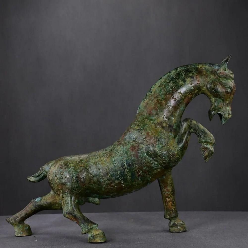 Antique Chinese Inscribed Bronze Horse Statue: Antique Chinese Inscribed Bronze Horse Statue This antique bronze horse statue features intricate inscriptions that add historical depth and cultural significance to its elegant design. Masterfully cr