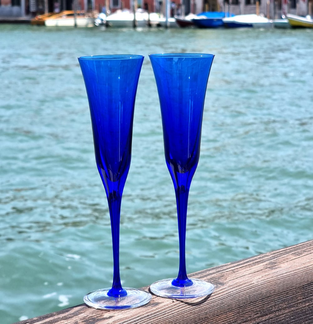Set of 2 Blue Murano Flute Glasses: Set of 2 Blue Murano Flute Glasses This collection of calice glasses draws inspiration from 1960s design, reimagined with a contemporary twist. Perfect for serving prosecco, sparkling wine, or champag