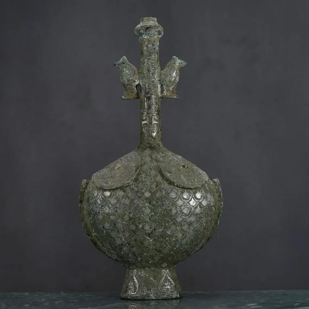 Antique Chinese Inlaid Silver Bronze Ornament: Antique Chinese Inlaid Silver Bronze Ornament This antique Chinese bronze ornament is adorned with intricate silver inlay, showcasing a stunning contrast between the warm bronze tones and the shimmeri