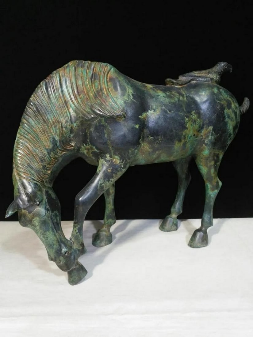Antique Chinese Grazing Horse Bronze Statue: Antique Chinese Grazing Horse Bronze Statue This antique Chinese bronze statue portrays a grazing horse, symbolizing peace, freedom, and vitality. The detailed craftsmanship captures the horse’s ser