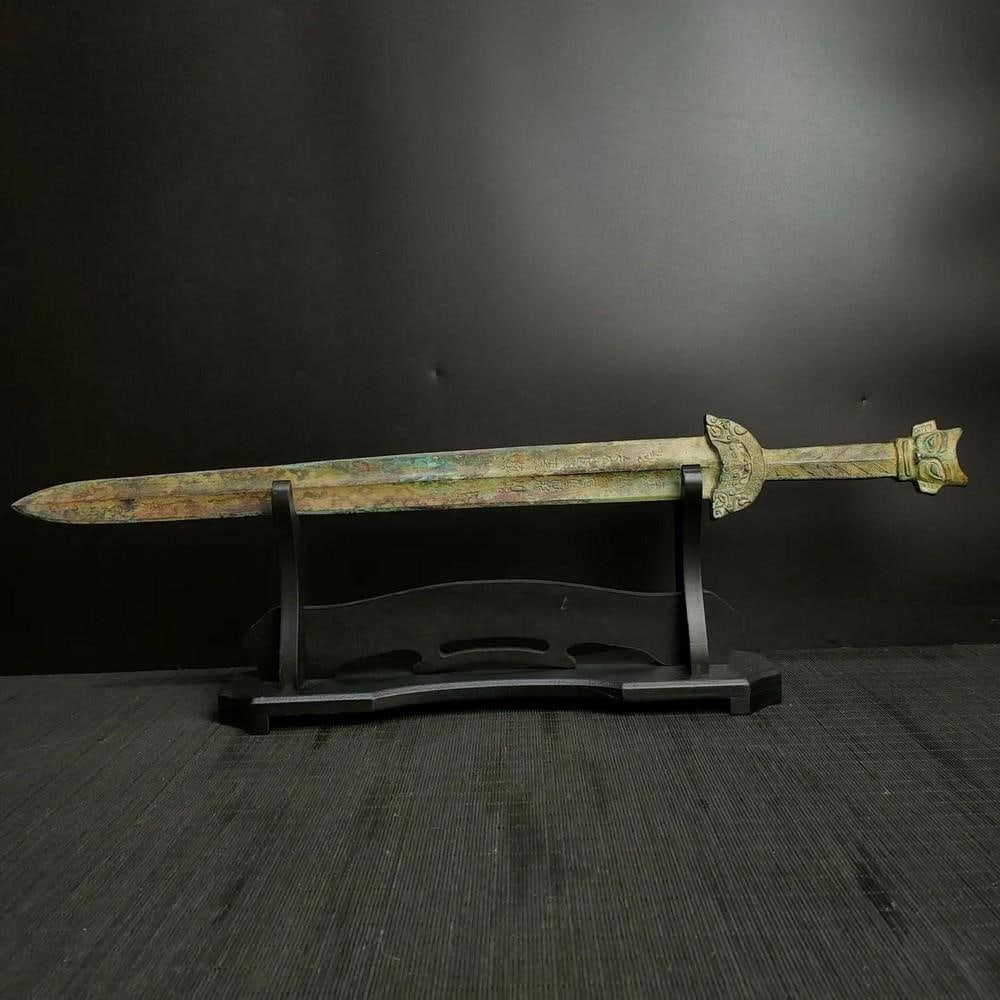 Antique Chinese Inscribed Bronze Sword Ornament: Antique Chinese Inscribed Bronze Sword Ornament This antique Chinese bronze sword ornament is intricately inscribed with traditional symbols, representing power, honor, and protection. The finely craf