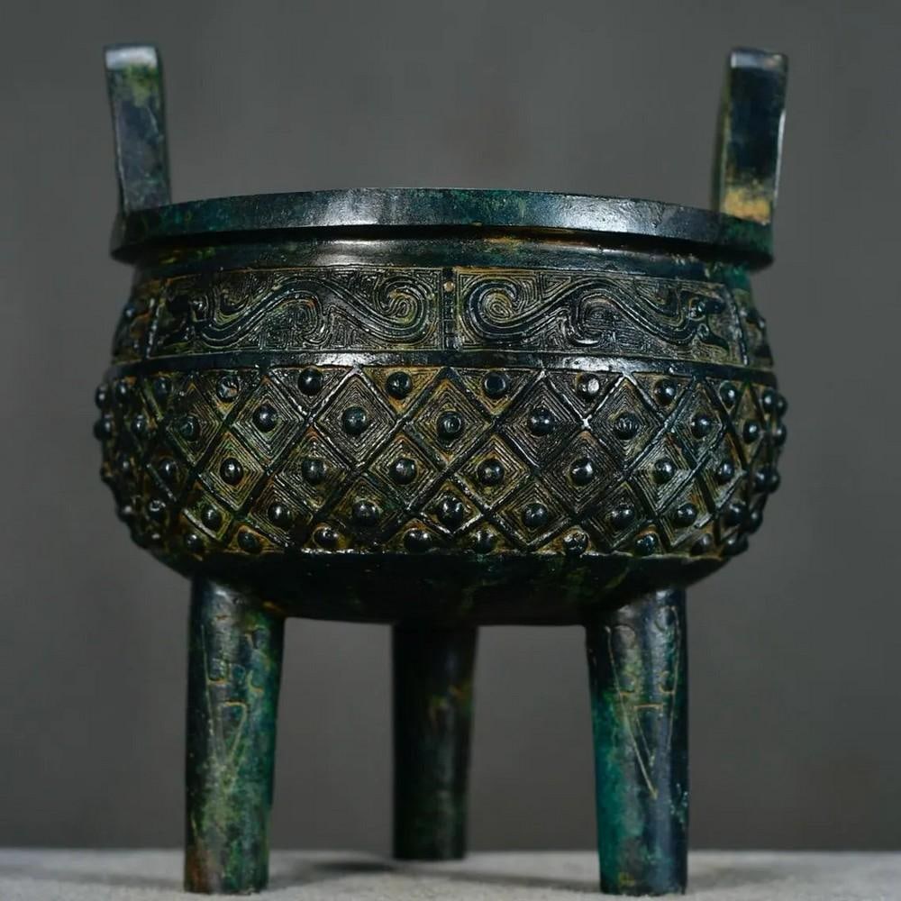 Antique Chinese Bronze Tripod Ornament: Antique Chinese Bronze Tripod Ornament This rare and exquisitely handcrafted bronze tripod embodies the elegance and cultural richness of ancient Chinese design. Its three-legged structure, symbolizin