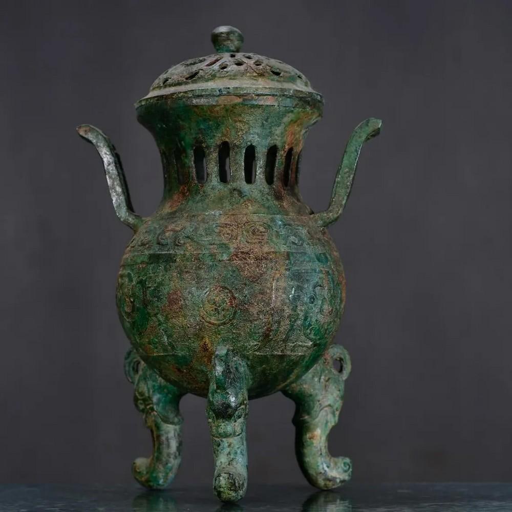 Antique Chinese Three-legged Bronze Incense Burner: Antique Chinese Three-legged Bronze Incense Burner This antique Chinese three-legged bronze incense burner is a striking example of traditional craftsmanship. The burner features a robust three-legged
