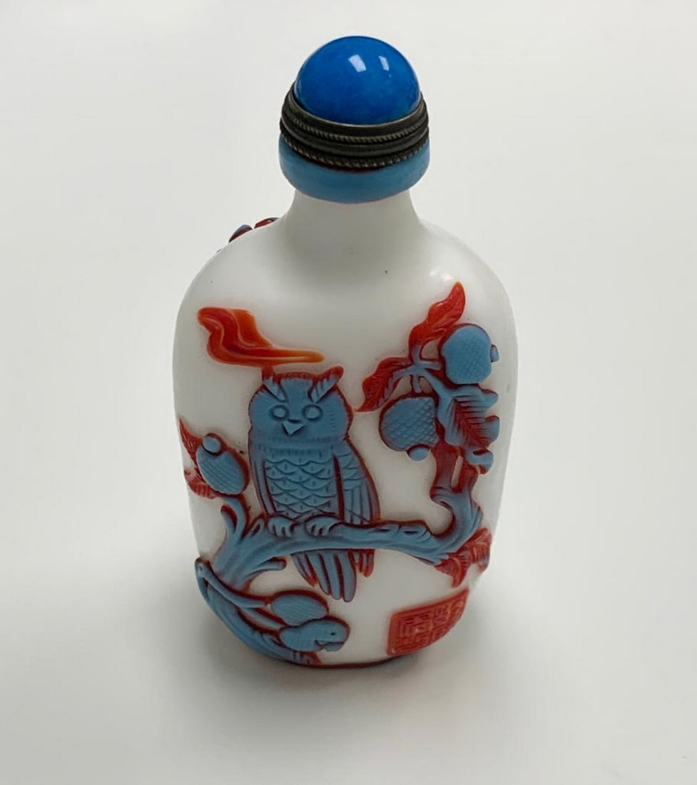 Porcelain Snuff Bottle with Owl and Bird Designs: Porcelain Snuff Bottle with Owl and Bird Designs This exquisite porcelain snuff bottle features a crisp white background adorned with intricate blue and red carvings. One side showcases an owl perched