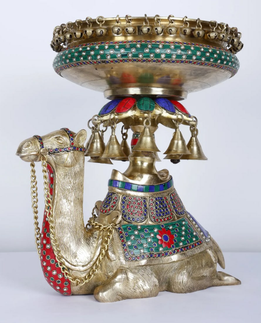 15" Camel Design Urli with Bells: 15" Camel Design Urli with Bells Brass urli featuring detailed inlay work and decorative camel motifs with small hanging bells. Suitable for holding water, flowers, or floating candles. Materials 