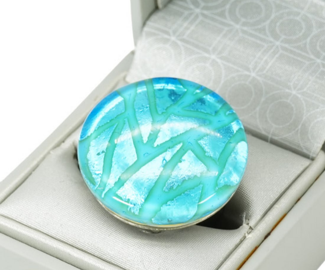 Charming Round Light Blue Murano Glass Ring with Silver Leaf: Charming Round Light Blue Murano Glass Ring with Silver Leaf This handcrafted Murano glass ring features the hot modeling technique and is adorned with engraved silver leaf. It has an adjustable size 