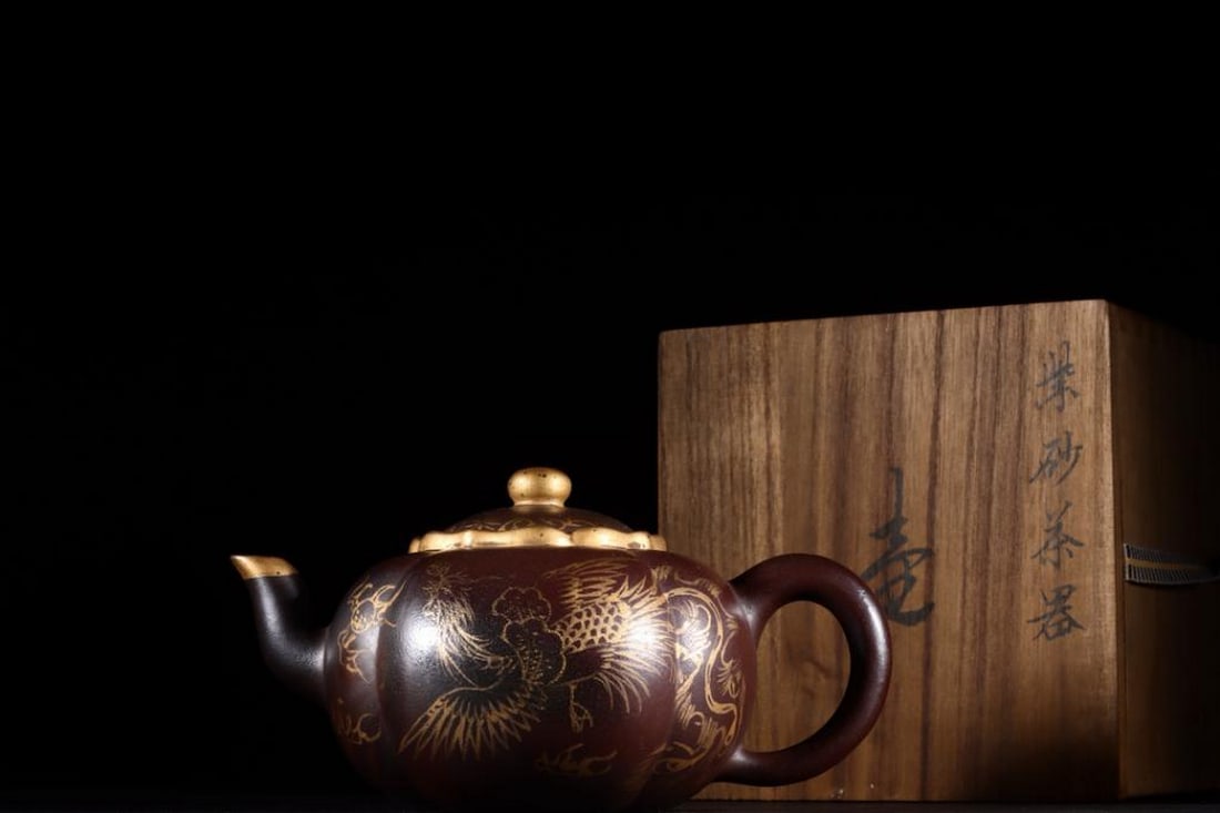 Inspired Zisha Teapot with Golden Phoenix and Auspicious Persimmon Motif: Inspired Zisha Teapot with Golden Phoenix and Auspicious Persimmon Motif A finely crafted inspired round Yixing Zisha teapot, bearing a Qianlong Year mark, featuring the elegant and symbolic motif of 
