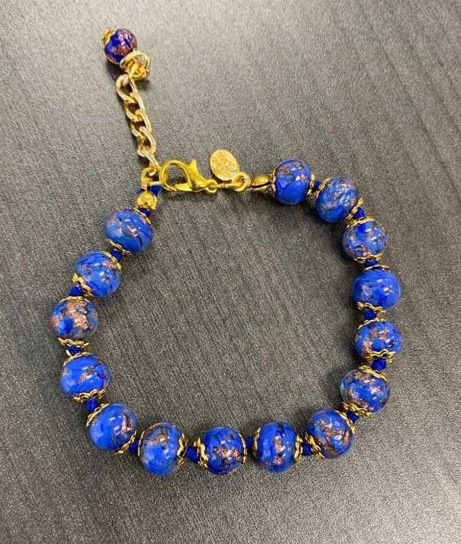Blue Murano Glass Bead Bracelet with Gold Accents: Blue Murano Glass Bead Bracelet with Gold Accents This elegant bracelet features luminous blue Murano glass beads delicately infused with gold accents, creating a timeless balance of color and shine. 