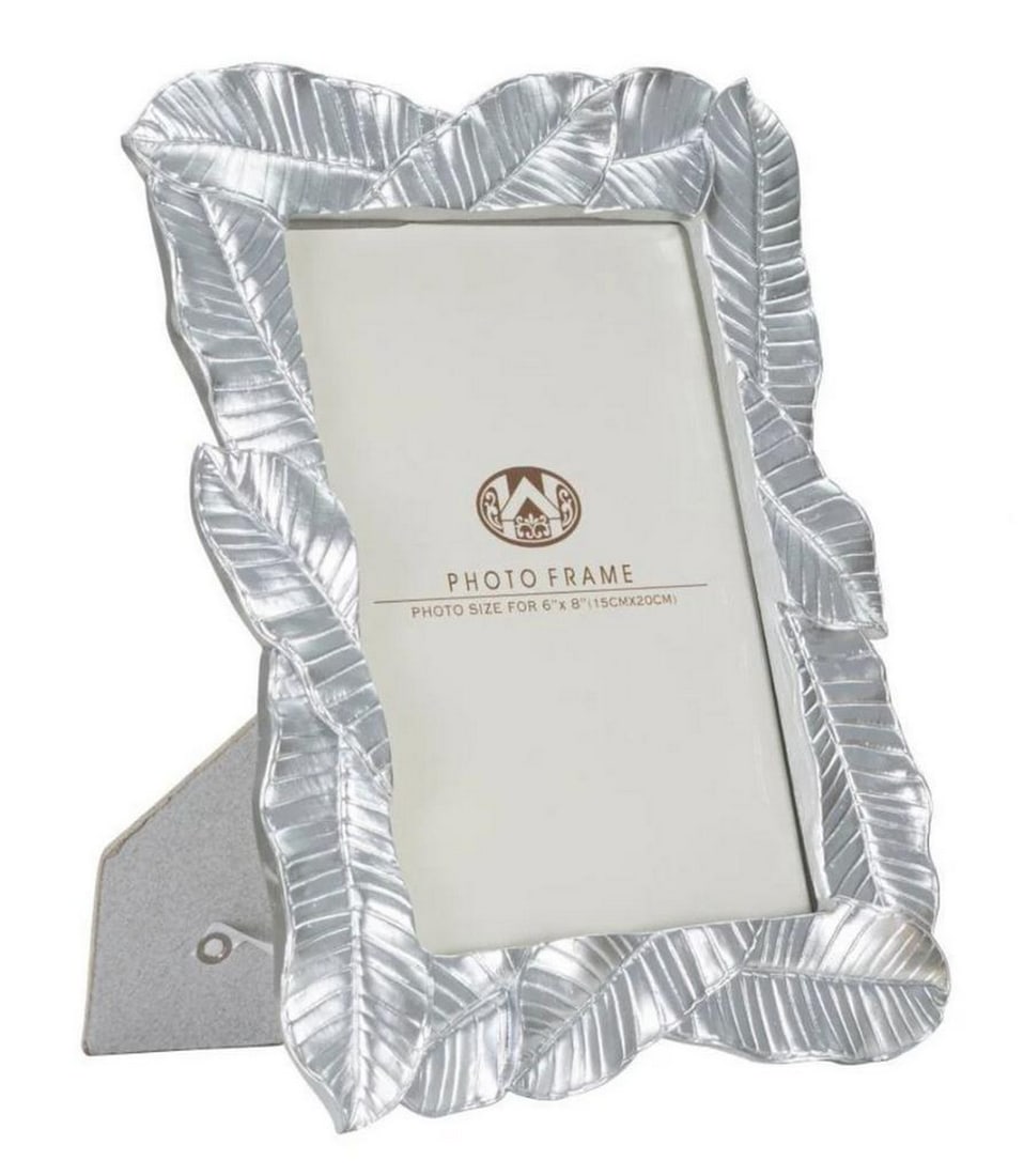 Photo Frame with Silver Leaf Finish: Photo Frame with Silver Leaf Finish Polyresin frame with glass, featuring elegant lines reminiscent of bay leaves, ideal for framing your cherished memories in a contemporary and distinctive style. Di