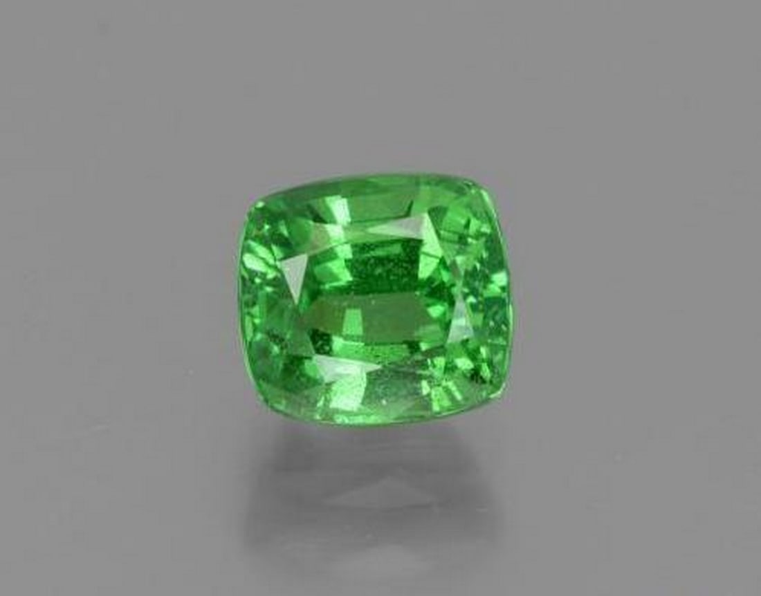 1.18 ct Cushion Natural Electric Green Tsavorite Garnet: 1.18 ct Cushion Natural Electric Green Tsavorite Garnet This natural 1.18-carat tsavorite garnet from Tanzania is cut in a classic cushion shape, showcasing a vivid electric green color with lively br