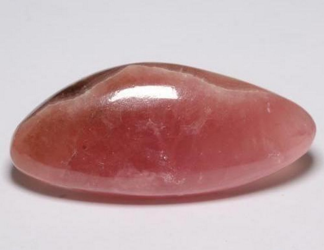 28.02 ct Fancy Natural Multicolor Rhodochrosite: 28.02 ct Fancy Natural Multicolor Rhodochrosite This natural 28.02-carat rhodochrosite from South Africa is cut in a unique fancy cabochon shape, showcasing a striking multicolor pattern with transluc