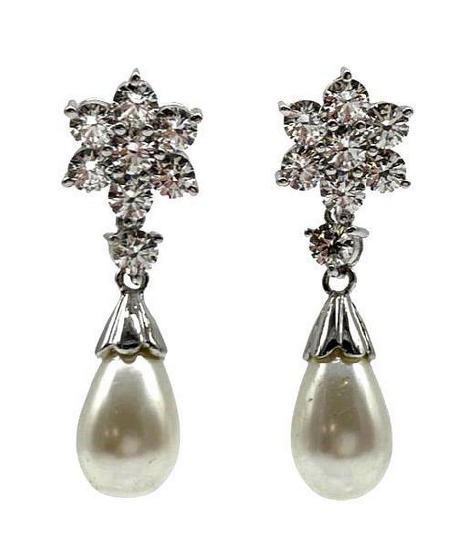 925 Sterling Silver Flower Pearl Earrings: 925 Sterling Silver Flower Pearl Earrings These earrings are made out of 925 sterling silver. At the top of the earring there is a flower made of of Austrian crystals and a pearl dangling beneath.