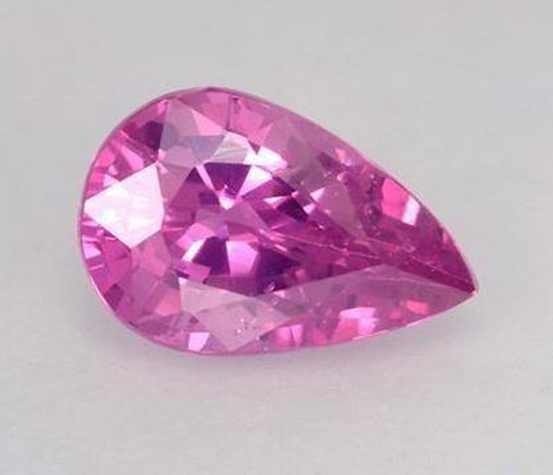 0.56 ct Pear Cut Faceted Bright Intense Pink Sapphire Gemstone: 0.56 ct Pear Cut Faceted Bright Intense Pink Sapphire Gemstone Introducing our Pear Cut Faceted Bright Intense Pink Sapphire Gemstone – a breathtaking fusion of elegance and vibrancy that commands a