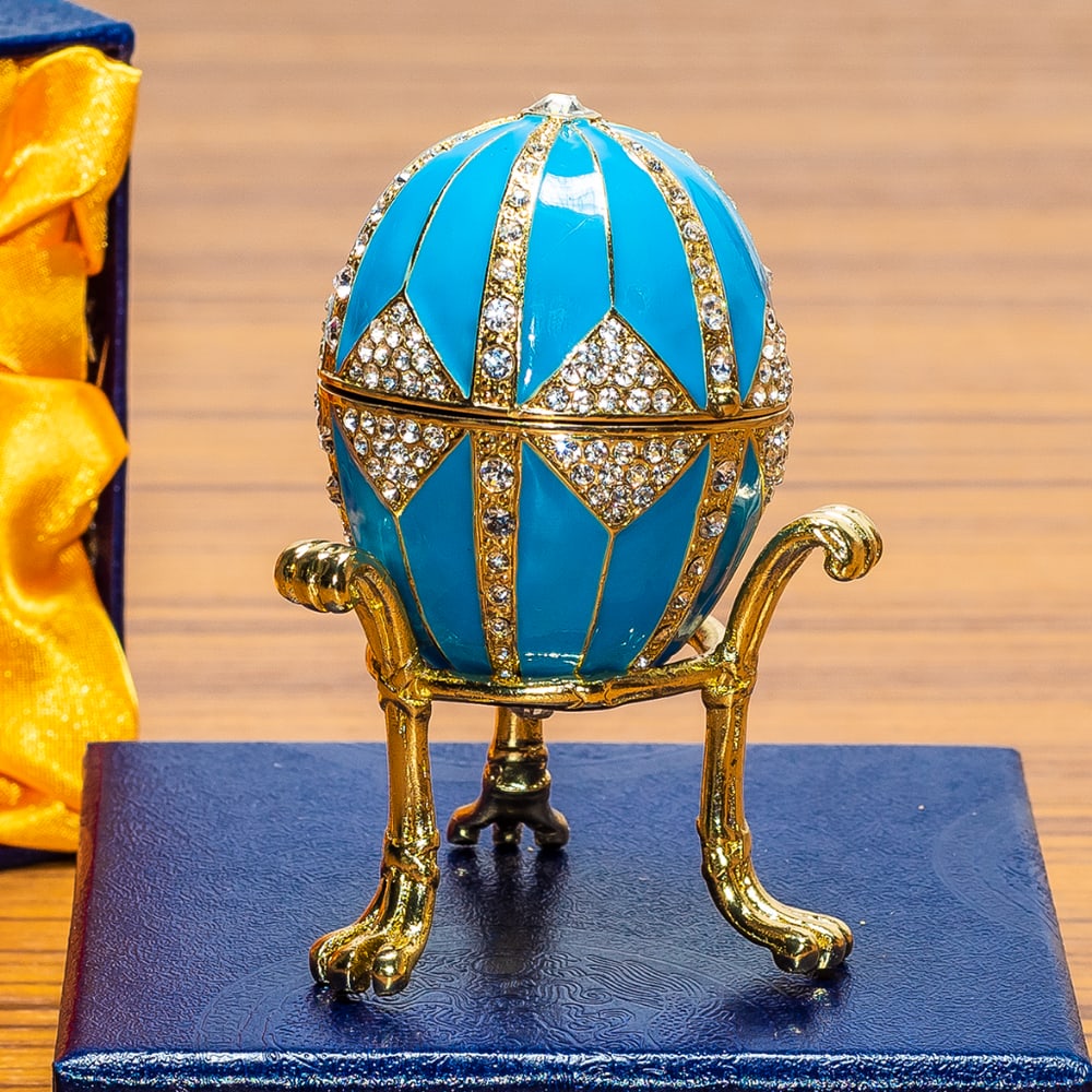 Crystal Rhombus on Blue Enamel Royal Inspired Russian Egg: Crystal Rhombus on Blue Enamel Royal Inspired Russian Egg This hand-painted sparkling egg is adorned with clear crystals and high-polished enamel with golden trim. The egg opens on a hinge and closes