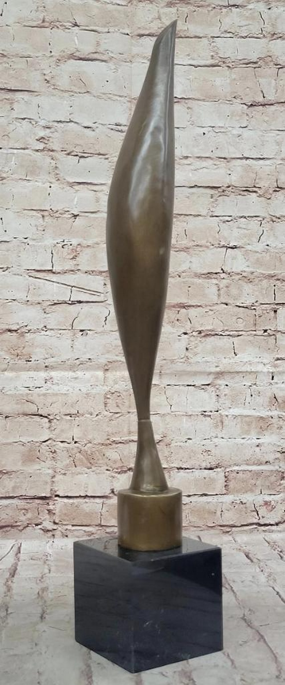 Bird in Space" Inspired Bronze Statue - 23" x 4: "Bird in Space" Inspired Bronze Statue - 23" x 4" The bronze statue in the image is an elegant representation inspired by “Bird in Space,” characterized by its tall, slender fo