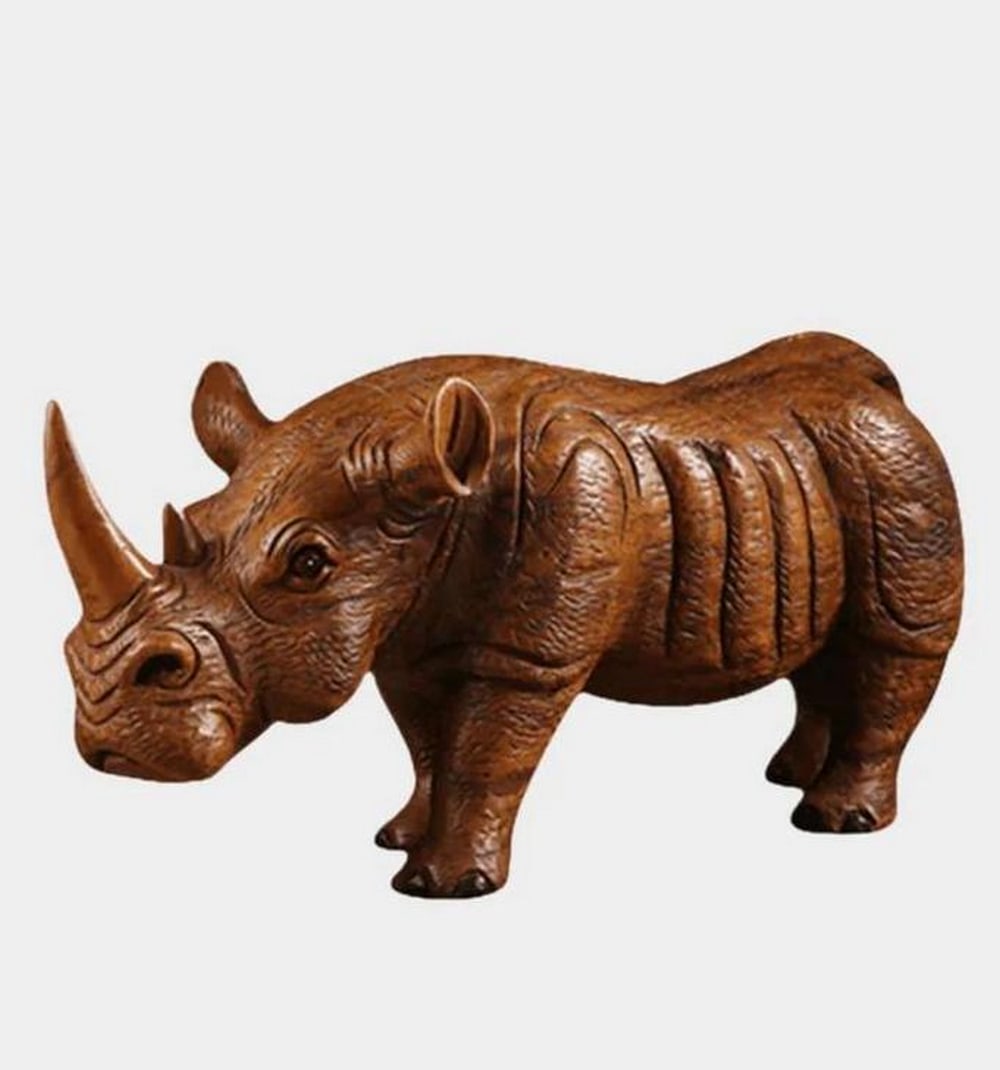 Hand-Carved Wooden Rhinoceros Sculpture: Hand-Carved Wooden Rhinoceros Sculpture This lifelike rhinoceros sculpture has been expertly carved from solid wood, highlighting the animal’s natural strength and presence. Detailed facial