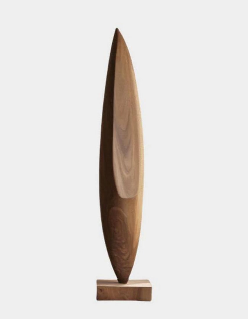 Carved Abstract Wooden Form on Rectangular Base: Carved Abstract Wooden Form on Rectangular Base An abstract carved sculpture crafted from solid wood, featuring a vertically oriented, tapered form with a smooth, streamlined curvature. The grain of