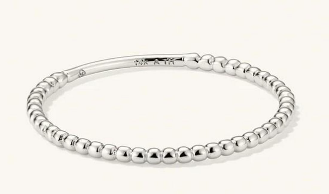 Delicate Beaded Stacking Ring: Delicate Beaded Stacking Ring A subtle essential with textural charm, this beaded ring features a continuous band of polished metal spheres that catch the light with every movement. Perfect for