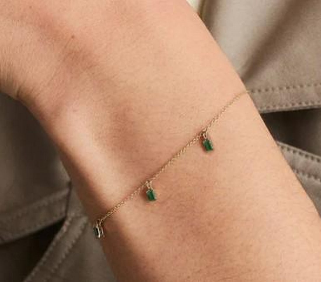 Floating Triple Baguette Gemstone Bracelet: Floating Triple Baguette Gemstone Bracelet Three baguette-cut gemstones are delicately spaced along a fine chain, giving the illusion of floating brilliance across the wrist. Each stone sways gently