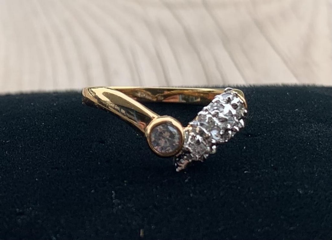 Golden Grace CZ Split Band Ring: Golden Grace CZ Split Band Ring An exquisite display of elegance and modern design, this gold ring features a distinctive split band—one side cradling a bezel-set round cubic zirconia, the other